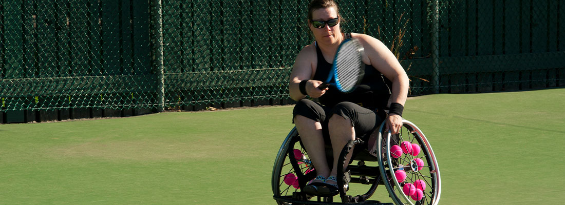 a woman playing wheelchair tennis 